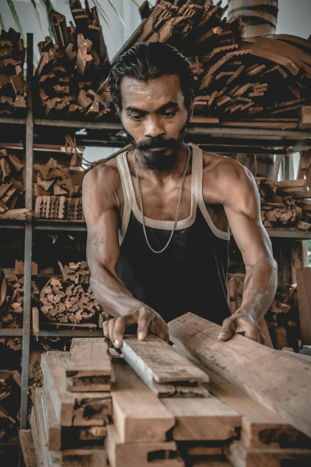 Carpenter planing a timber board at his bench