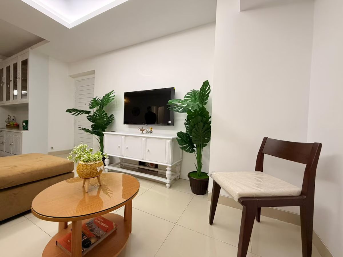 Living room, from the dining side Living room with a round timber table and plants