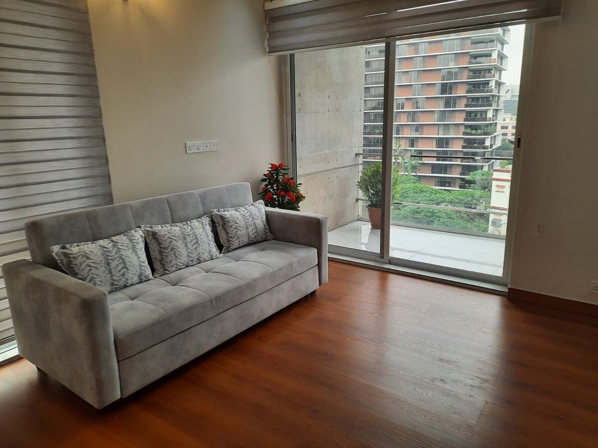 Family lounge Sofa on timber flooring by a balcony door